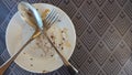 Empty dirty plate, a plates remained after eating and drinking drinks on a wooden table in the rays of the bright Royalty Free Stock Photo