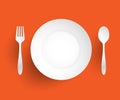 Empty dish, fork and spoon placed alongside. On orange background