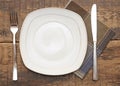 Empty dish, knife and fork and brown napkin Royalty Free Stock Photo