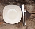 Empty dish, knife and fork and brown napkin Royalty Free Stock Photo