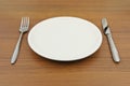 Empty dish, knife and fork on wood table Royalty Free Stock Photo