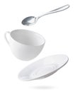 Empty dishes cup, plate and spoon are flying on a white. Isolated Royalty Free Stock Photo