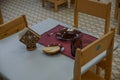 Empty dishes set for breakfast in kindergarden. Kindergarten indoor view. Chairs and tables. Furniture.