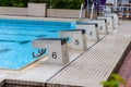 Diving block stands with numbers in outdoor swimming pool on rainy day Royalty Free Stock Photo