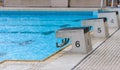 Diving block stands with numbers in outdoor swimming pool on rainy day Royalty Free Stock Photo