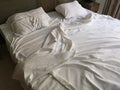 Empty double bed and unmade white