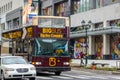 An empty double decker hop on hop off tour big bus on a street in center city Philadelphia on a cold wet overcast day