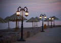 Empty embankment with straw umbrellas and streetlights in Dahab at night