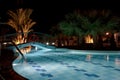 Empty enlightened swimming pool in a hotel resort during hot summer night Royalty Free Stock Photo