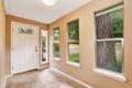 Empty entryway with tile floor and white front door.