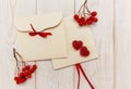 Empty envelopes with red rowan and stripe. Two red hearts jujube. White wooden table