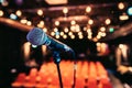 Empty event hall: Close up of microphone stand, empty seats in the blurry background Royalty Free Stock Photo