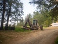 Empty excavator surrounded by green vegetation.