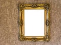 Empty expensive looking antique golden painting frame work hanging on a jute cloth wall background