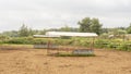 Empty farm corral wet ground and metal feeding shades