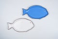 Empty fish-shaped blue and white plates on white background.