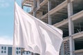 empty flag mockup waving in front of a halffinished building Royalty Free Stock Photo