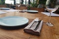 Empty flat plate, empty glass and cutlery on brown wooden table. Table setting in restaurant Royalty Free Stock Photo