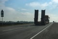 Empty flatbed platform truck with lowbed semi-trailer road rear side view Royalty Free Stock Photo