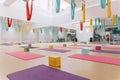 Empty flying yoga studio with colourful hammocks with colourful yoga blocks and mats on wooden texture floor at yoga studio.