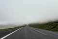 Empty foggy and misty asphalt road through the the mountain, no