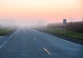 Empty foggy road at sunrise