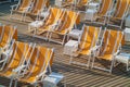 Empty folding beach chairs on a wooden deck Royalty Free Stock Photo