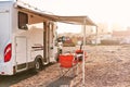 Empty folding chairs and table under canopy near recreational vehicle camper trailer Royalty Free Stock Photo