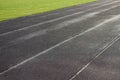 An empty football field. Soccer field grass. Graphite running road track with white marking lines near green football Royalty Free Stock Photo