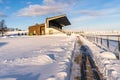 Empty Football (Soccer) Stadium Seats in the Winter Partly Covered in Snow - Sunny Winter Day Royalty Free Stock Photo