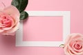 Empty frame and beautiful roses on pink background, top view. Space for text Royalty Free Stock Photo