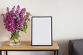 Empty frame and bouquet of purple lilac in a vase Royalty Free Stock Photo