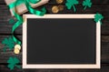 Empty frame for text, gold coins, clover shamrock and gift with green ribbon on a dark wooden background. Good luck Royalty Free Stock Photo