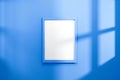 Empty frame on vivid blue wall background with natural light of window. Display of showing exhibition. Realistic 3D render