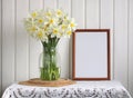 empty frame and white daffodils in a glass jug. Royalty Free Stock Photo