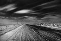 Empty freeway at night. Black and white. Road to the horizon. Clouds, rapidly running across the sky. Royalty Free Stock Photo