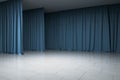 Empty gallery, stage with blue curtains, concrete floor and ceiling, illuminated artificially, corner view, exhibition and