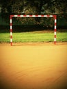 Empty gate. Outdoor football or handball playground, light red crushed bricks surface on ground