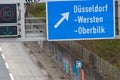 Empty German Autobahn in Dusseldorf with blue street signs and white arrows without traffic jam shows multiple lane highway ready Royalty Free Stock Photo