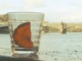 Empty glass of alcohol drink or cocktail have fresh orange slice one piece inside, have ashes of cigarette on wood table Royalty Free Stock Photo