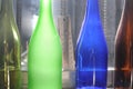 Empty glass bottles standing in a row, green, blue and brown Royalty Free Stock Photo