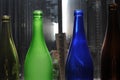 Empty glass bottles standing in a row, green, blue and brown Royalty Free Stock Photo