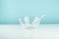 Empty glass bowl and spoon on a table.