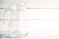 An empty glass carafe for water stands on a white wooden background Royalty Free Stock Photo