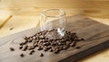 Empty glass with coffee beans around on a wooden table.