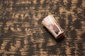 Empty glass covered in paint fallen on a black-brown surface