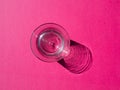 Empty glass with deep shadow on pink Royalty Free Stock Photo