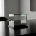 Empty Glass Display Case with Black Base on Dark Table in Softly Lit Room cube Royalty Free Stock Photo