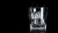 Empty glass with ice cube on dark background with cooling smoke and blank space. Ice blocks for beverage Royalty Free Stock Photo