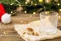 empty glass from milk and crumbs from cookies for Santa Claus in front of a Christmas tree lights bokeh Royalty Free Stock Photo